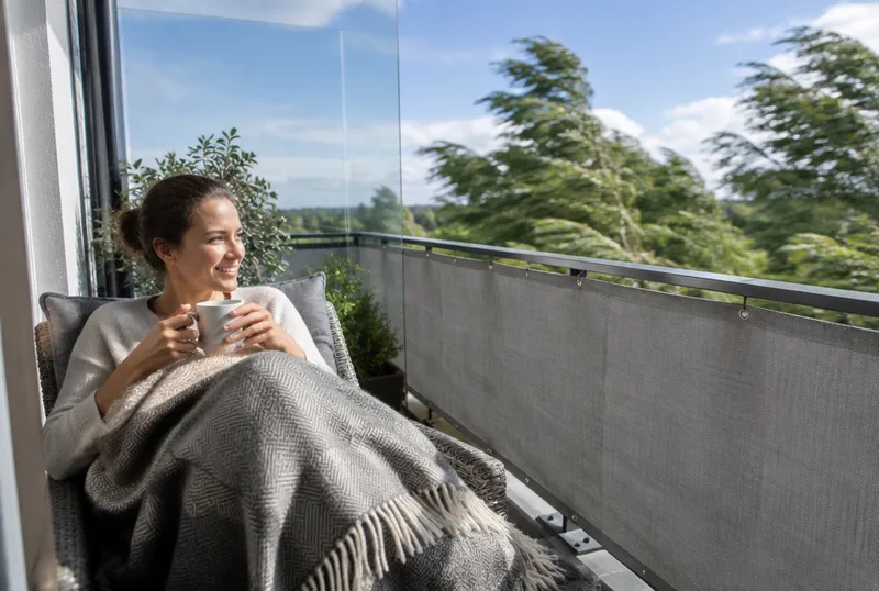 Windgeschützter Balkon mit Glaswand und Gewebebespannung